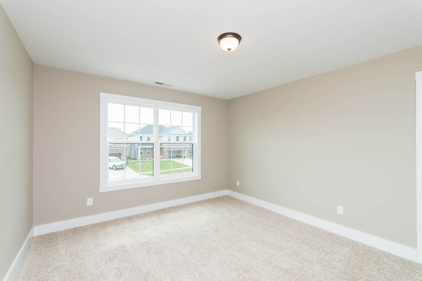 Mulberry Builders new construction home bedroom with carpet flooring and a large window.
