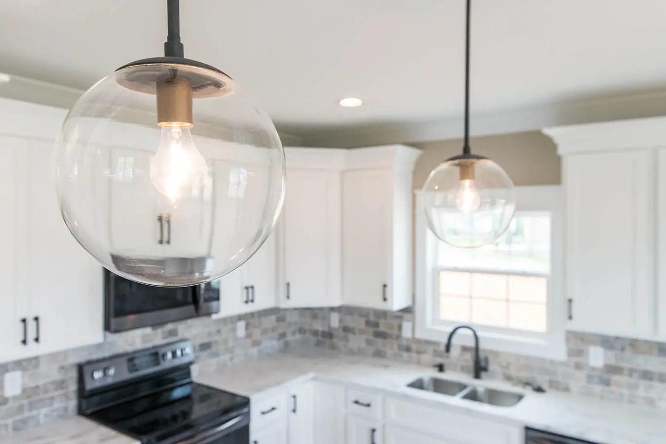 Mulberry Builders kitchen remodel with old-fashioned round glass hanging lamps.